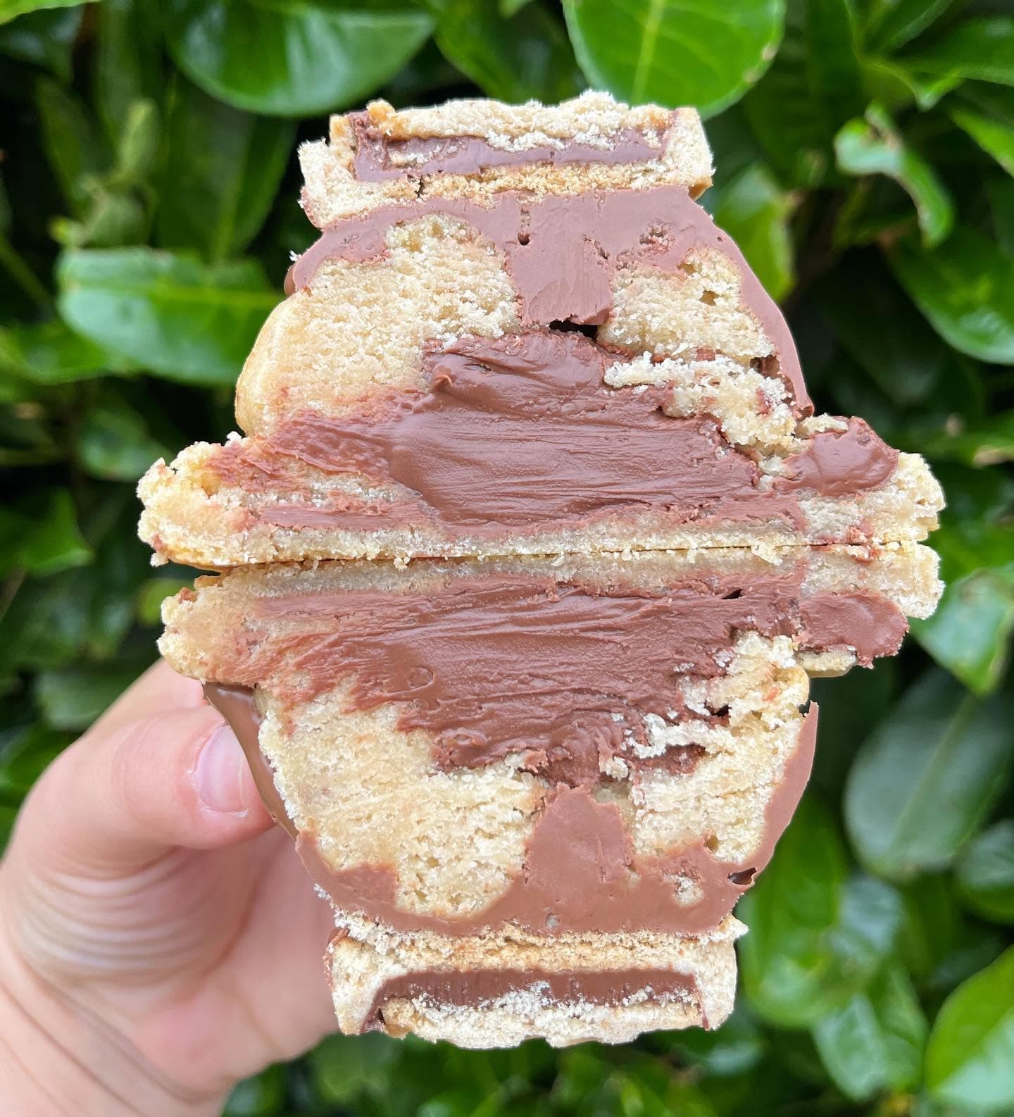 Nutella deluxe stuffed cookie cut open with a thick chocolate centre