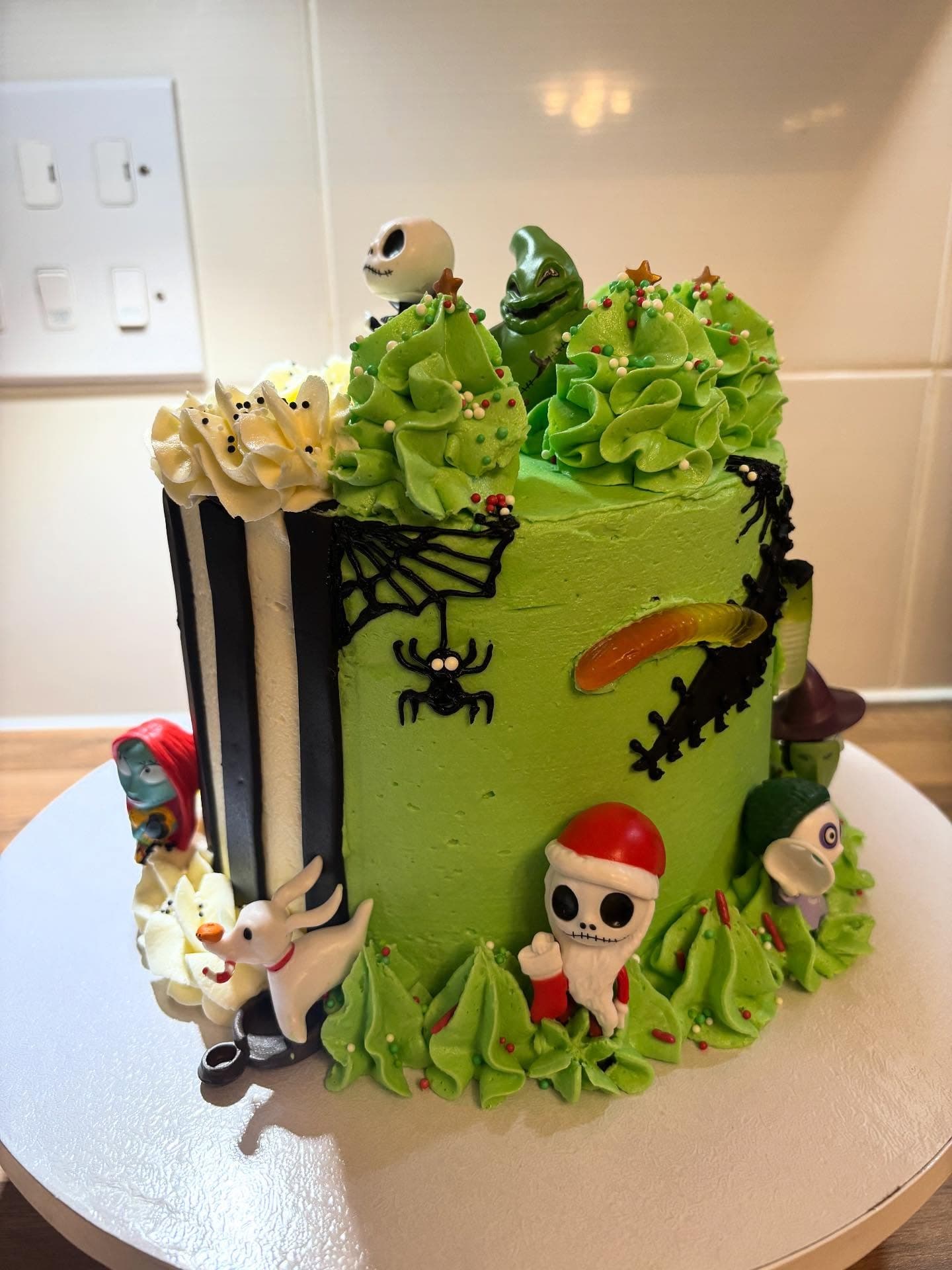 Bright green character themed cake with black and white stripes