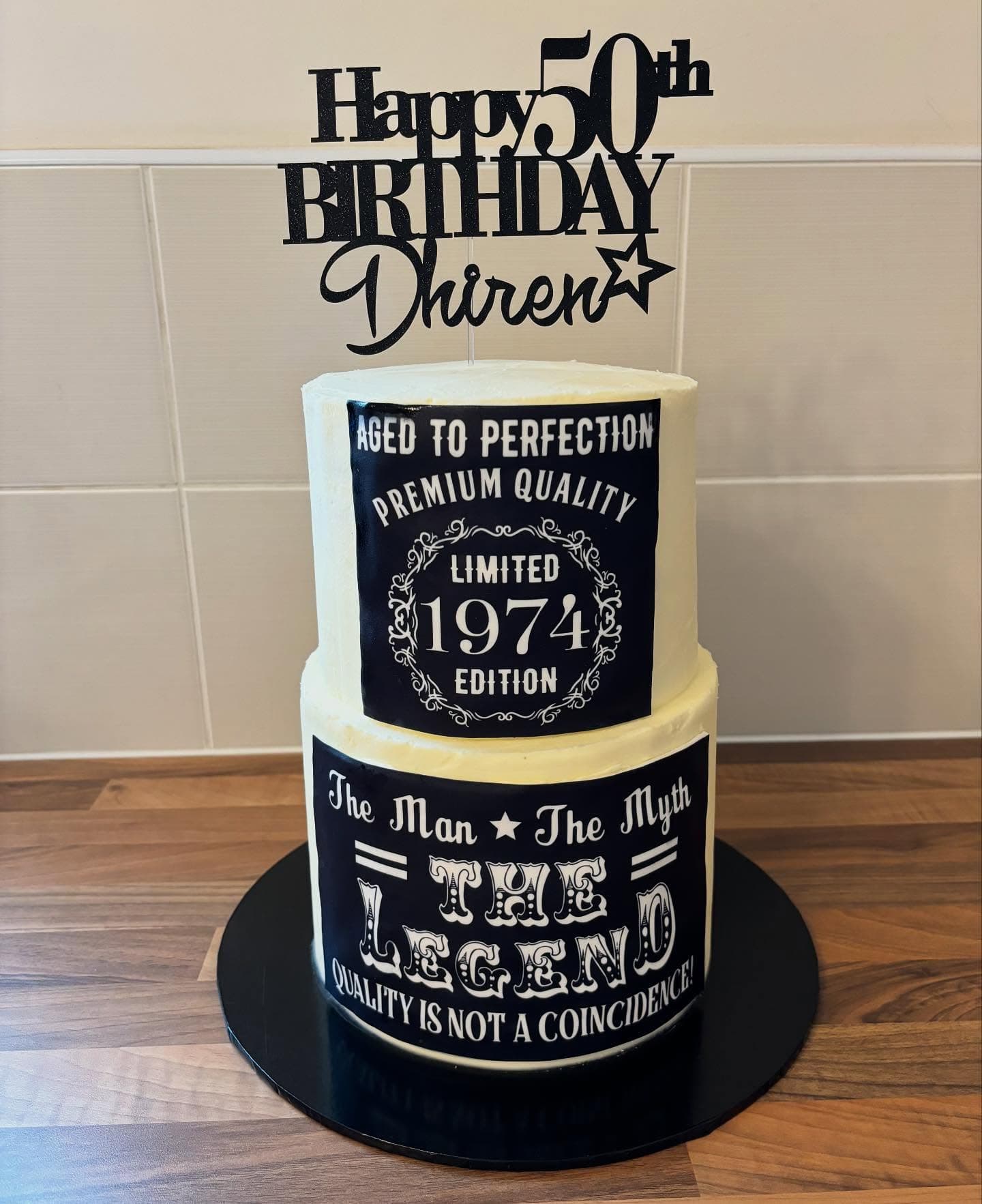 Two tier black and cream fiftieth birthday cake
