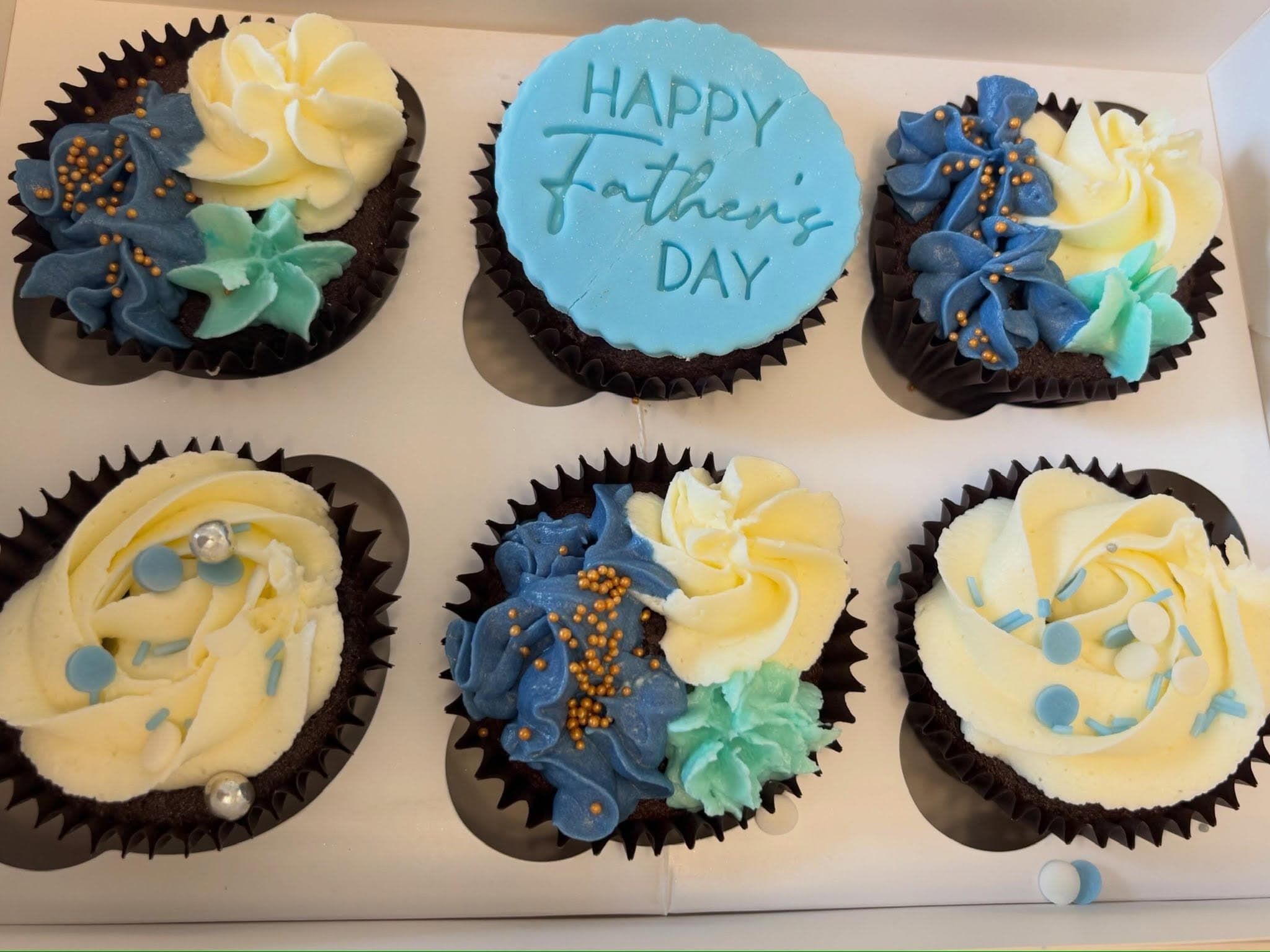 Box of Father's Day cupcakes with blue and cream buttercream