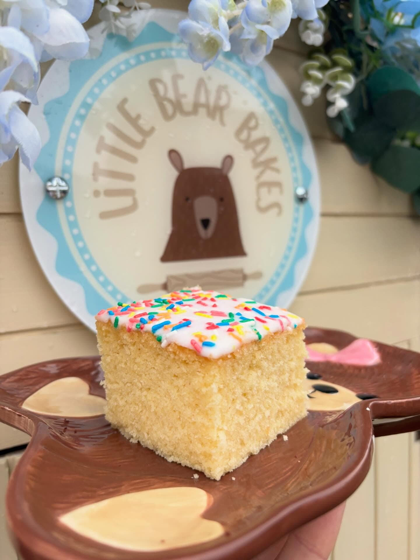 Sprinkle cake square with white icing and rainbow sprinkles