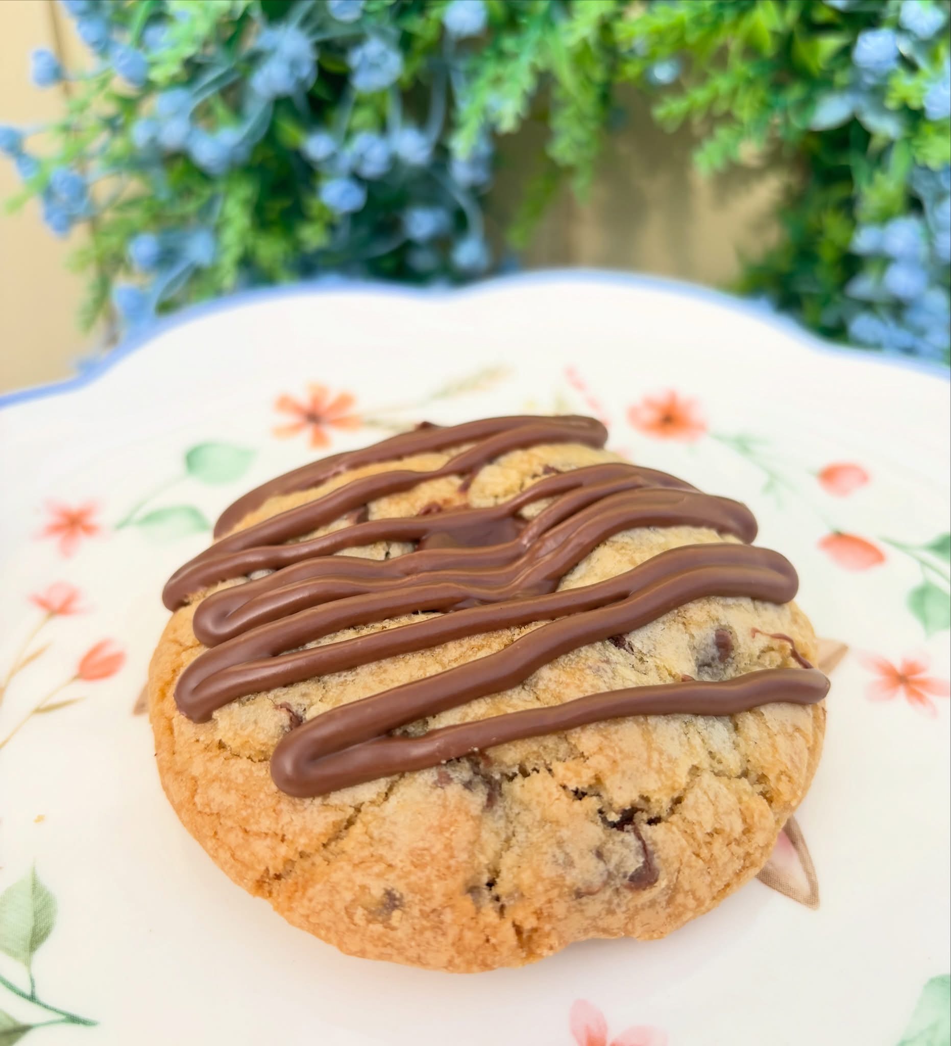 A single Nutella Stuffed Cookie topped with chocolate drizzle