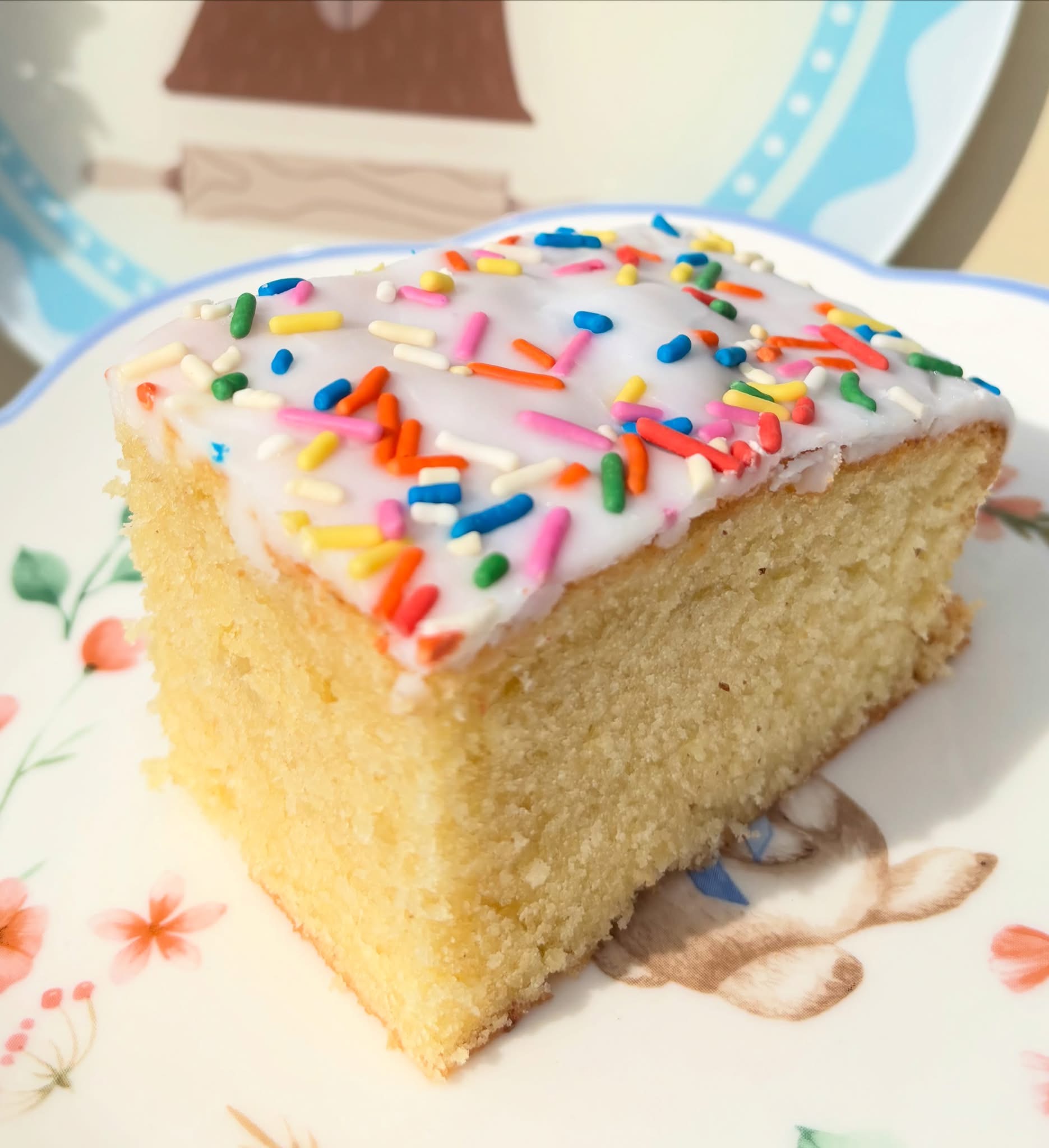 Sprinkle cake square with white icing and rainbow sprinkles