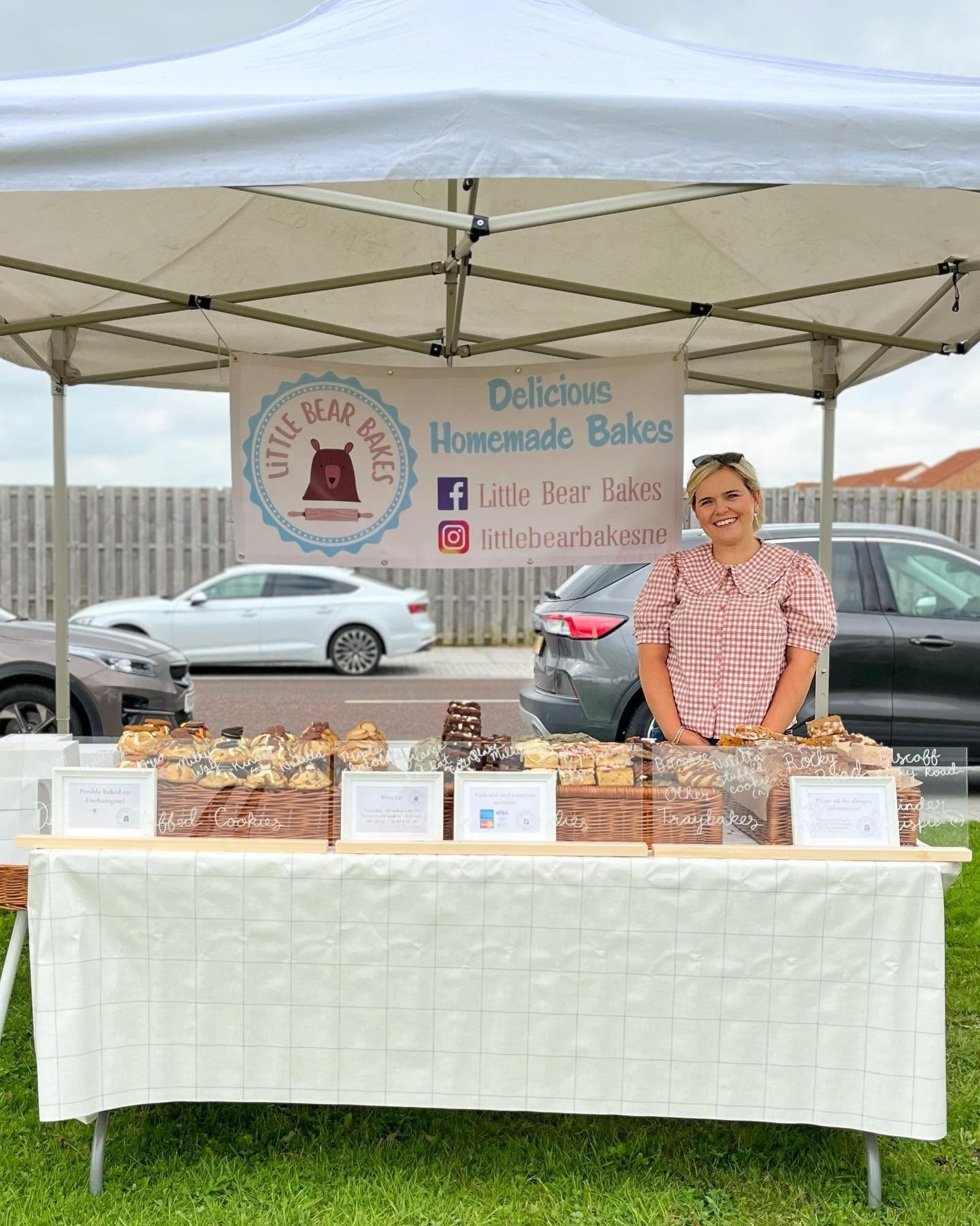 Little Bear Bakes market stall, with freshly baked treats and our baker behind the counter